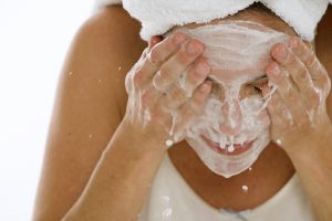 Close-up of a young woman splashing water on her face